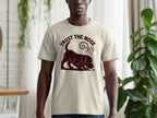 Light tan t-shirt with a dark brown graphic of a dog sniffing and the text "TRUST THE NOSE".