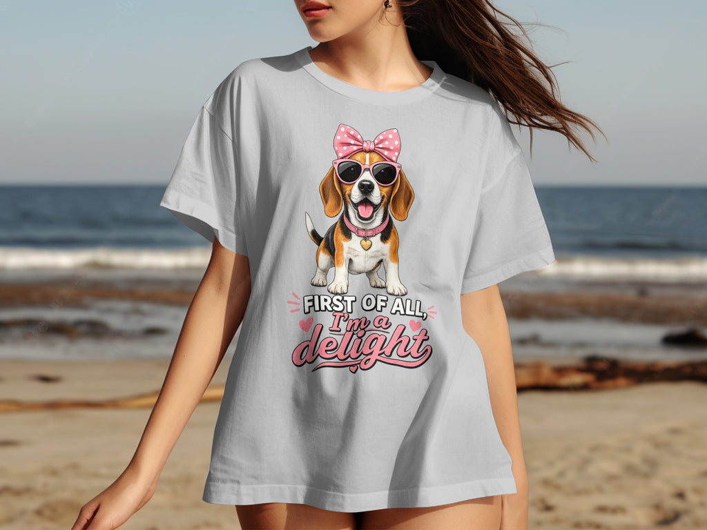 Light gray t-shirt with a beagle wearing pink sunglasses and a bow, reading "First of all, I'm a delight."