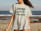 Light gray t-shirt with "STAY WILD CHASE THE LURE" text and dog silhouette.