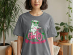 T-shirt with pug in sunglasses riding a pink bicycle, text reads "Off to cause a kerfuffle".
