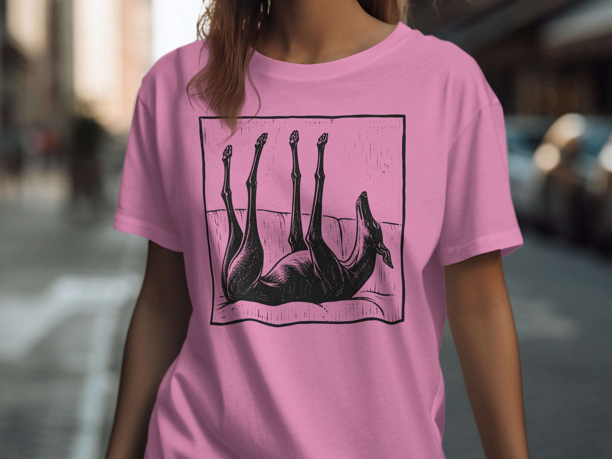 Black dog silhouette on a pink t-shirt, lying on its back.