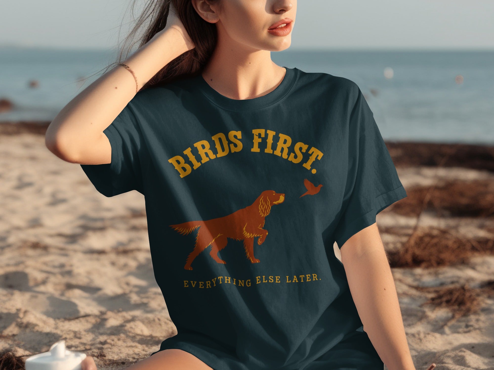 Dark blue t-shirt with "BIRDS FIRST. EVERYTHING ELSE LATER." and dog pointing at bird graphic.