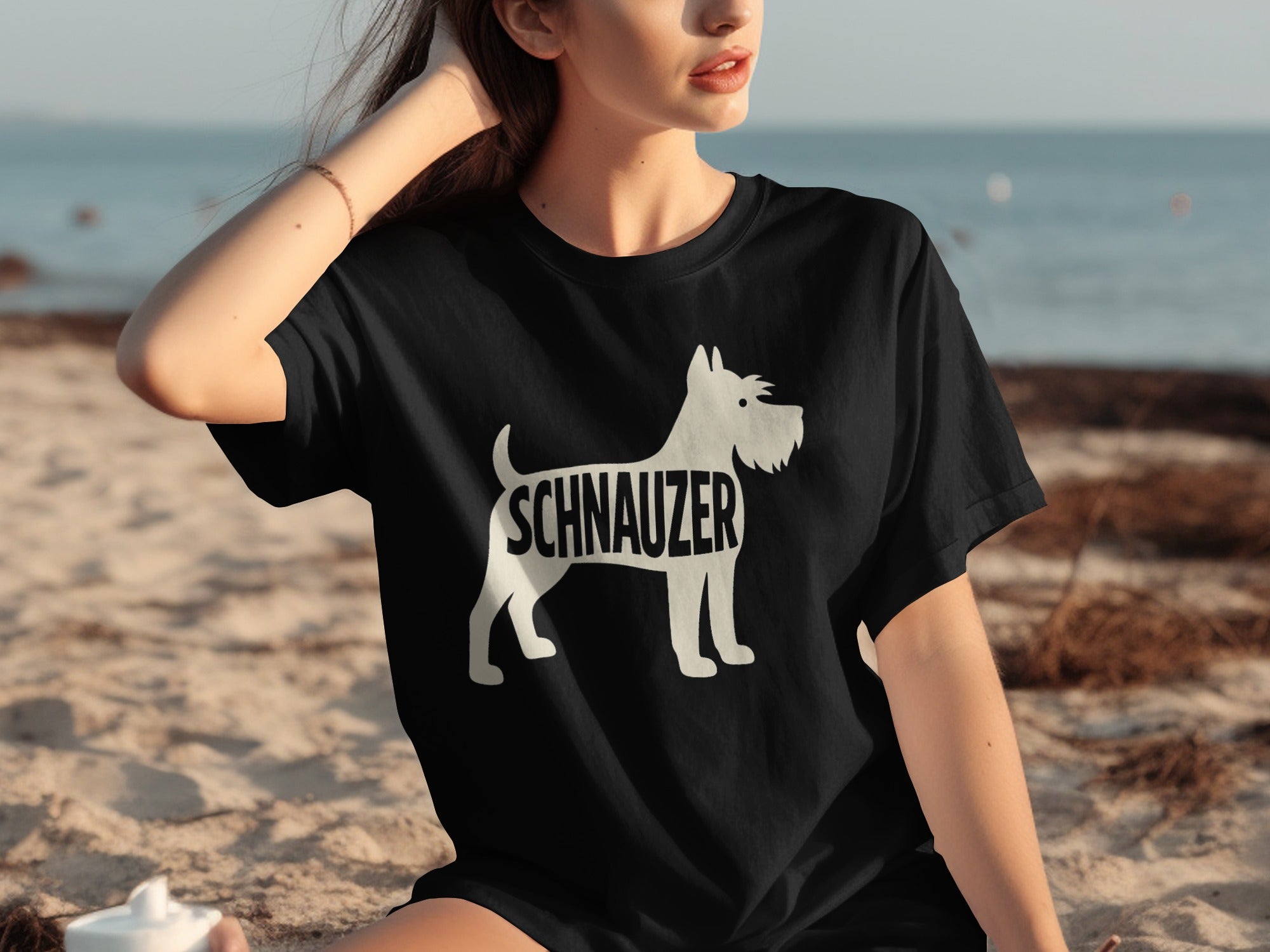 Black t-shirt with white schnauzer silhouette and text on a beach.