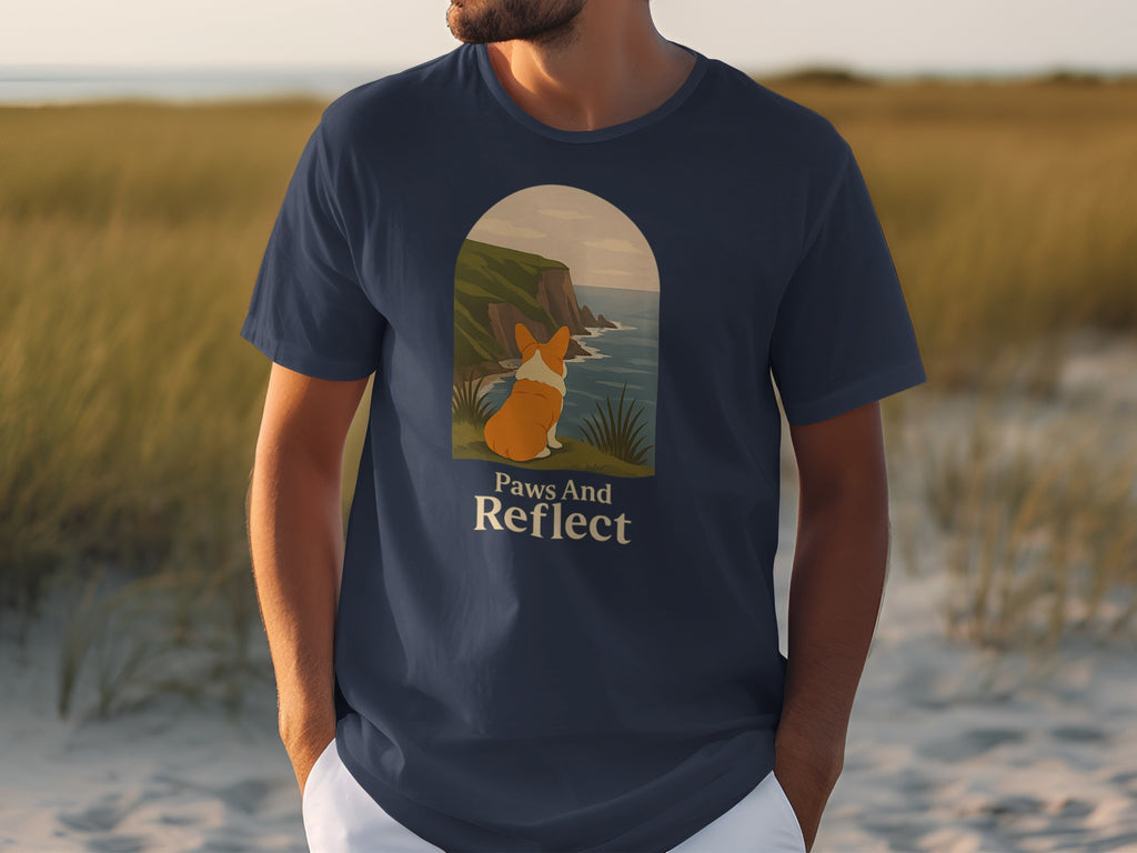 T-shirt with a corgi looking at the ocean and text that reads "Paws And Reflect".