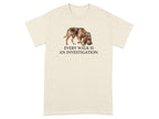 Cream t-shirt with watercolor bloodhound in hat and text "EVERY WALK IS AN INVESTIGATION".