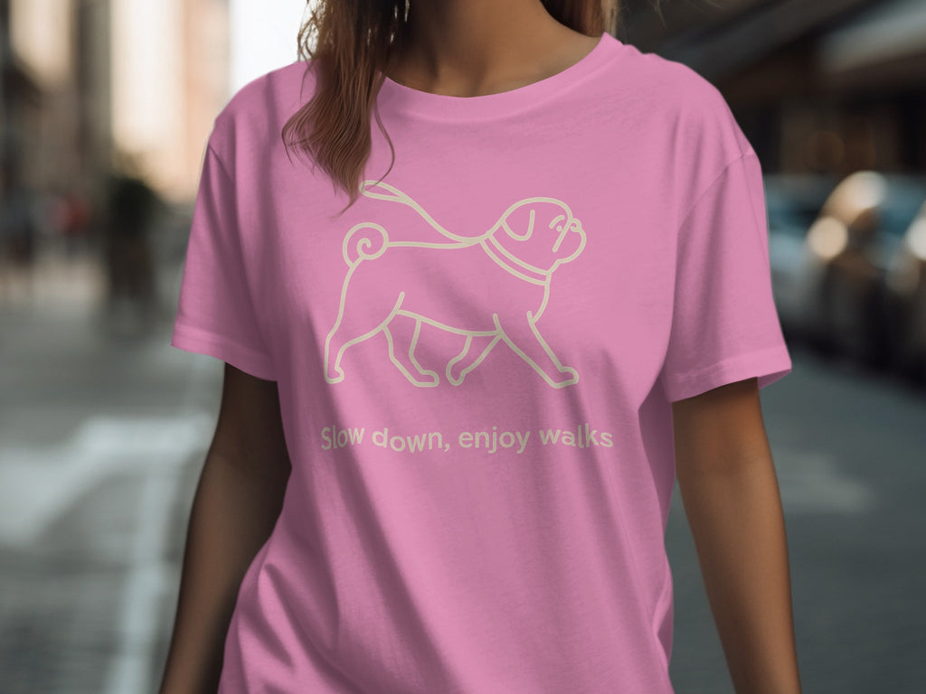 Pink t-shirt with a pug illustration and text: "Slow down, enjoy walks".