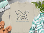 Beige sweatshirt with a golden retriever outline and text "Slow down, enjoy walks".