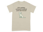 Beige t-shirt with a seated dog graphic and "Life update: someone walked past the house!" text.