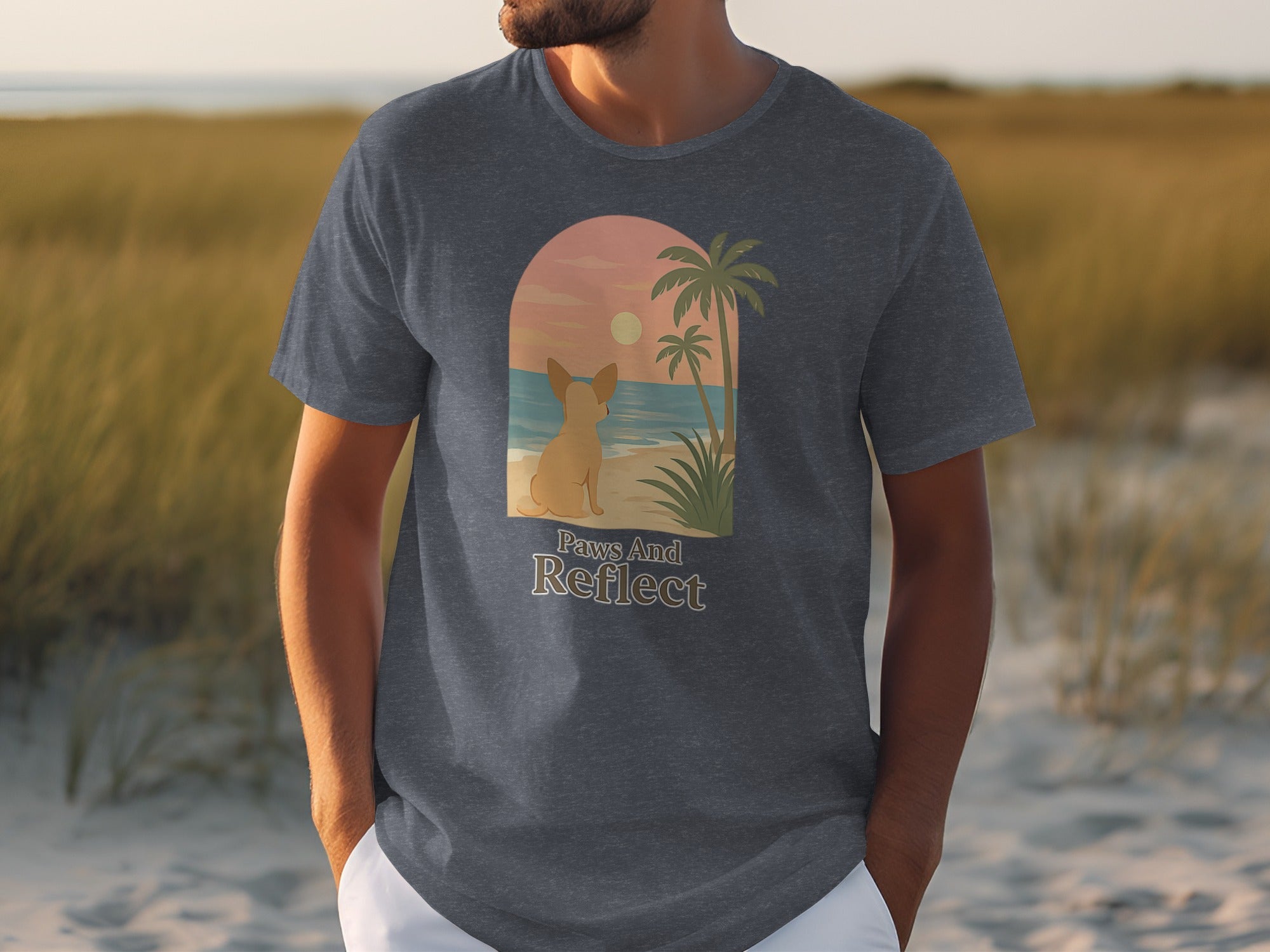 T-shirt with arched graphic of dog on beach at sunset, text "Paws And Reflect".