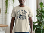 Beige t-shirt with a dark blue graphic of a poodle sniffing the ground and text "TRUST THE NOSE."
