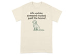 Cream t-shirt with text "Life update: someone walked past the house!" and a sitting dog graphic.