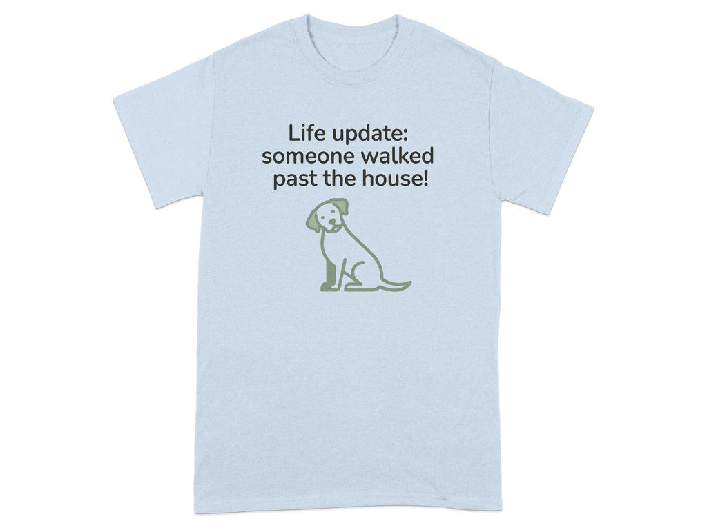 Light blue t-shirt with green dog graphic and text "Life update: someone walked past the house!"