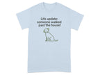 Light blue t-shirt with green dog graphic and text "Life update: someone walked past the house!"