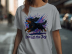 T-shirt with a black dog jumping through colorful splatters and "Unleash the Joy" text.