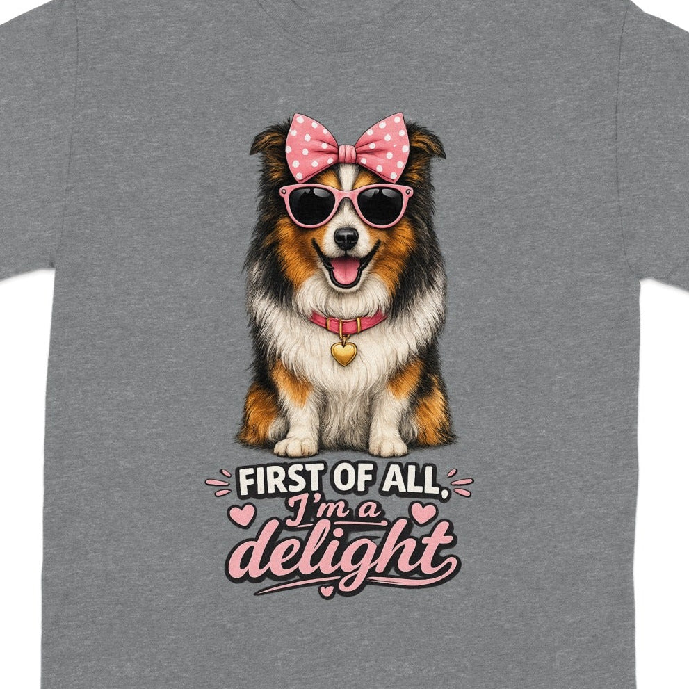 T-shirt with happy dog wearing pink bow, sunglasses, and "First of all, I'm a delight" text.
