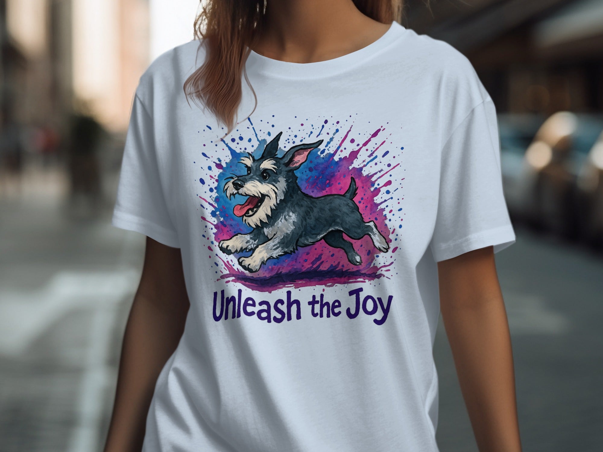 White t-shirt with a black and grey dog design and purple text "Unleash the Joy".