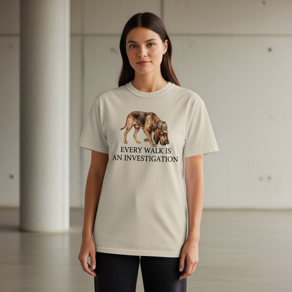 Light-colored t-shirt with a dog wearing a hat, "Every Walk Is An Investigation" text.