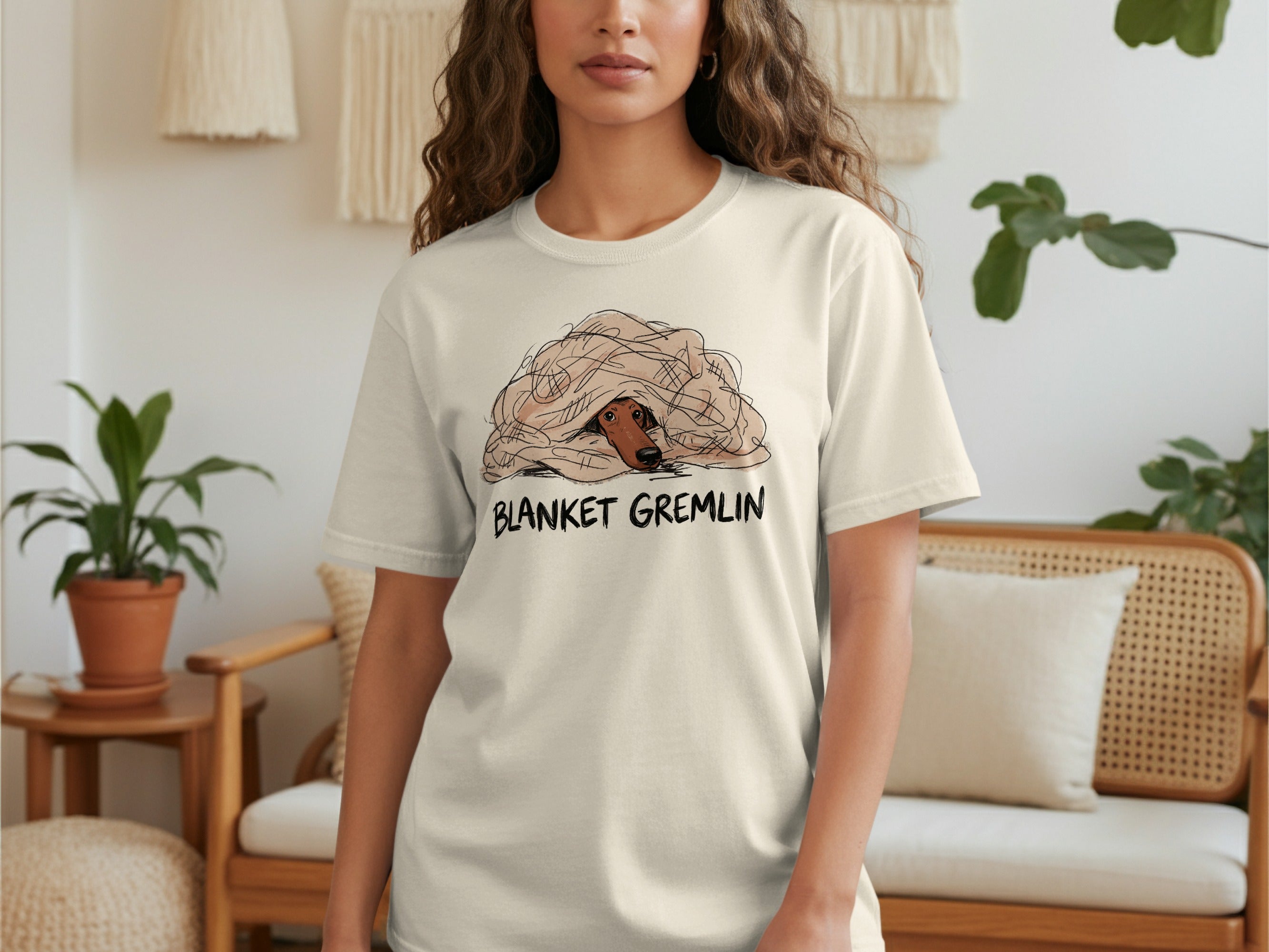 Cream t-shirt with a dog peeking out from under a blanket, "BLANKET GREMLIN" text.