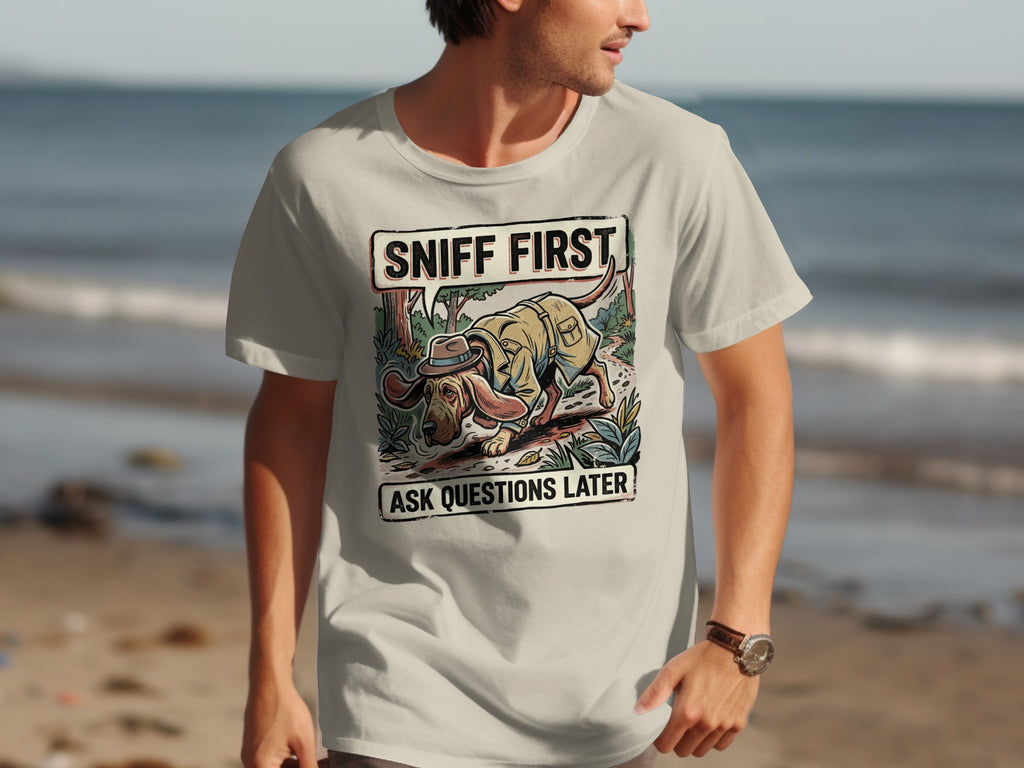 T-shirt graphic with a cartoon dog in a hat sniffing the ground with text "SNIFF FIRST ASK QUESTIONS LATER".