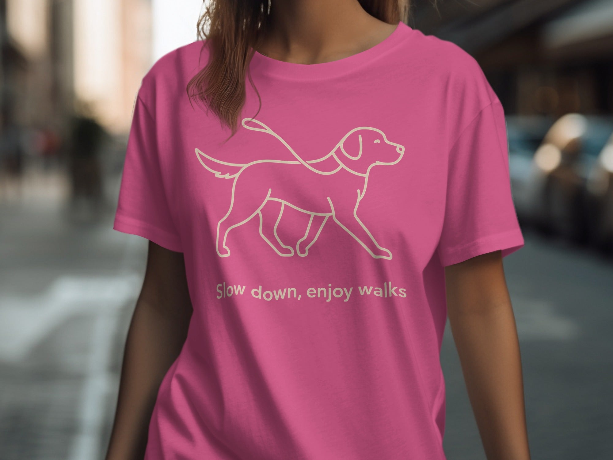 Pink t-shirt with a line drawing of a dog and text "Slow down, enjoy walks."