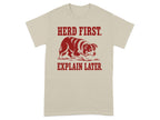Beige t-shirt with dog and "Herd First. Explain Later." text.