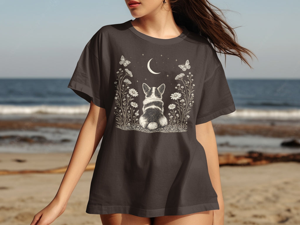 Dark grey t-shirt with a white graphic of a corgi amongst flowers and a moon.