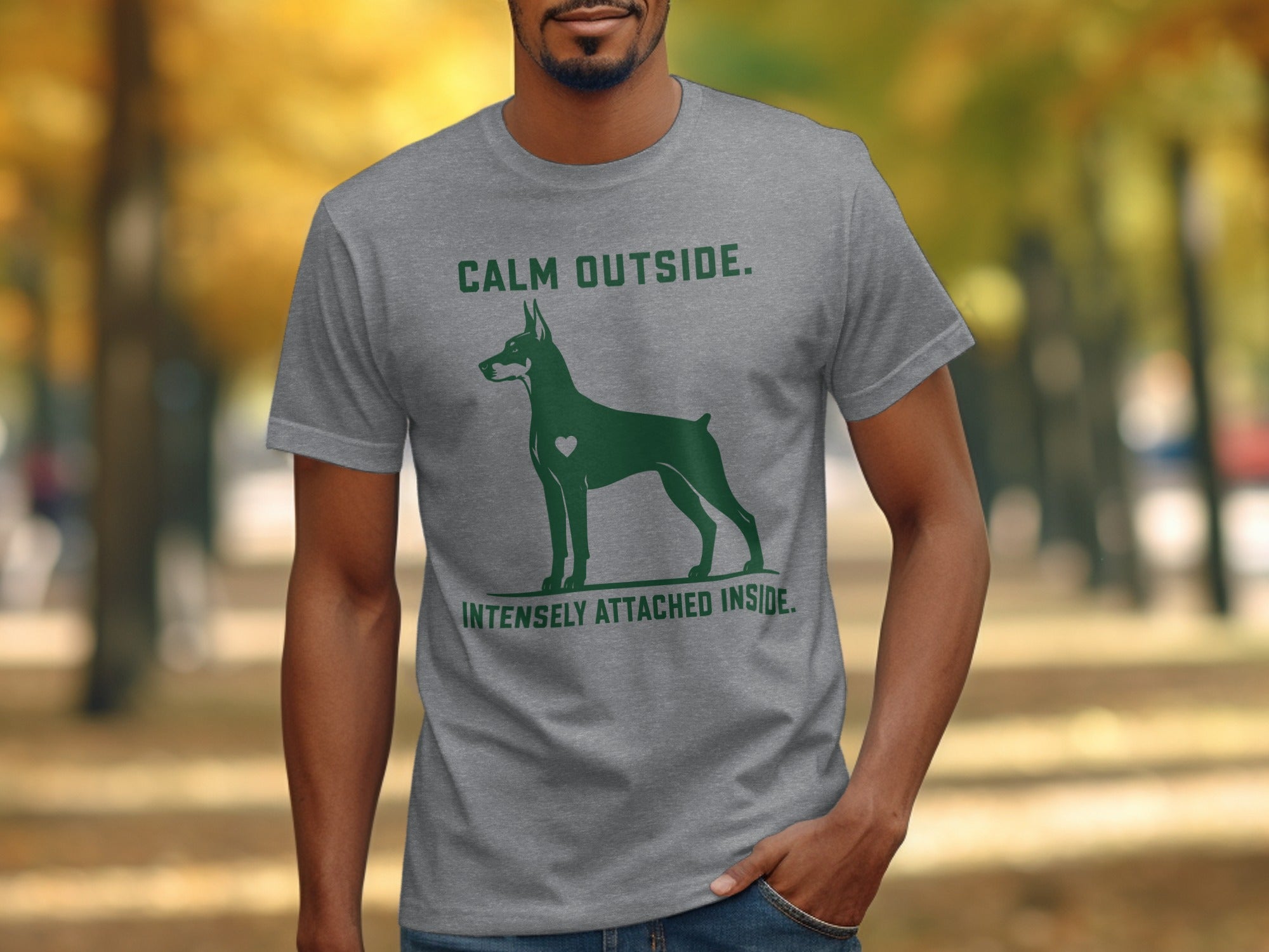 Grey t-shirt with green Doberman graphic and text: "CALM OUTSIDE. INTENSELY ATTACHED INSIDE."