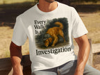 White t-shirt with a golden retriever wearing a hat, text reads "Every Walk Is an Investigation."