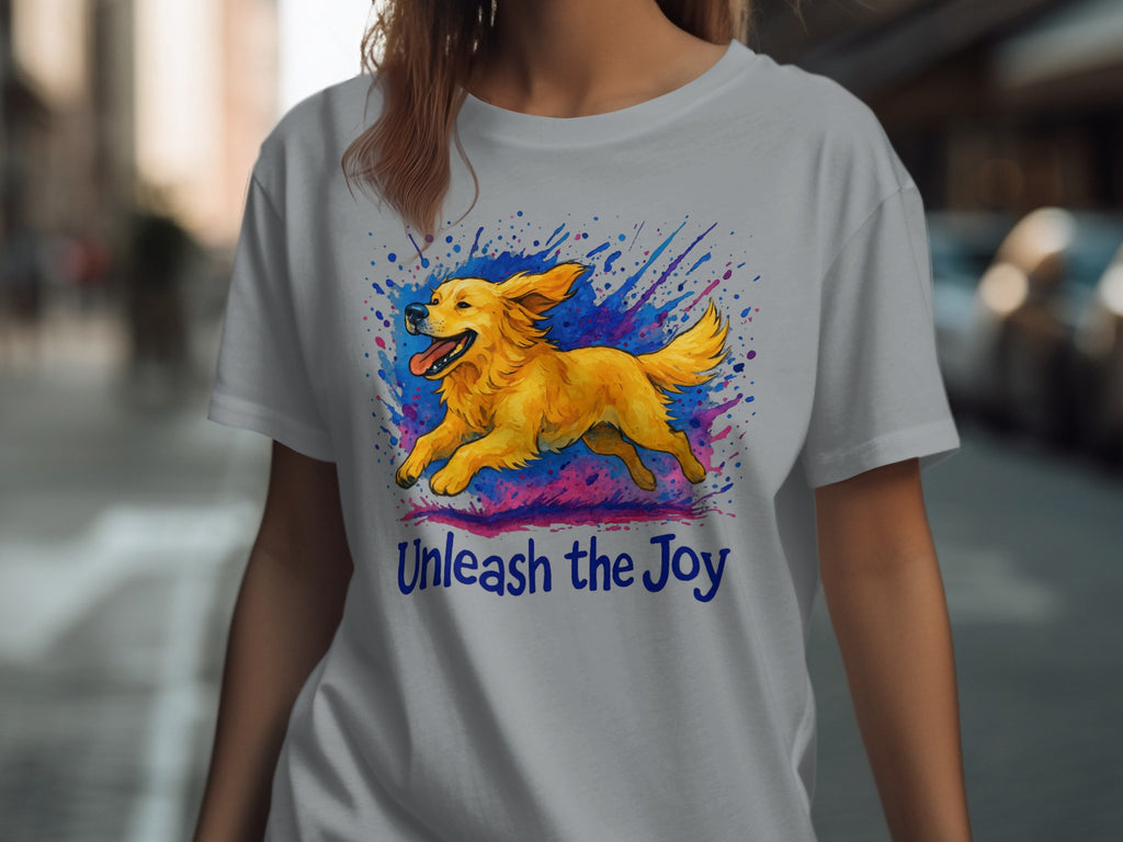 Grey t-shirt with a golden retriever running through colorful paint splatters and the text "Unleash the Joy".