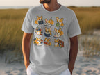 T-shirt graphic of corgis reading and sleeping with books.