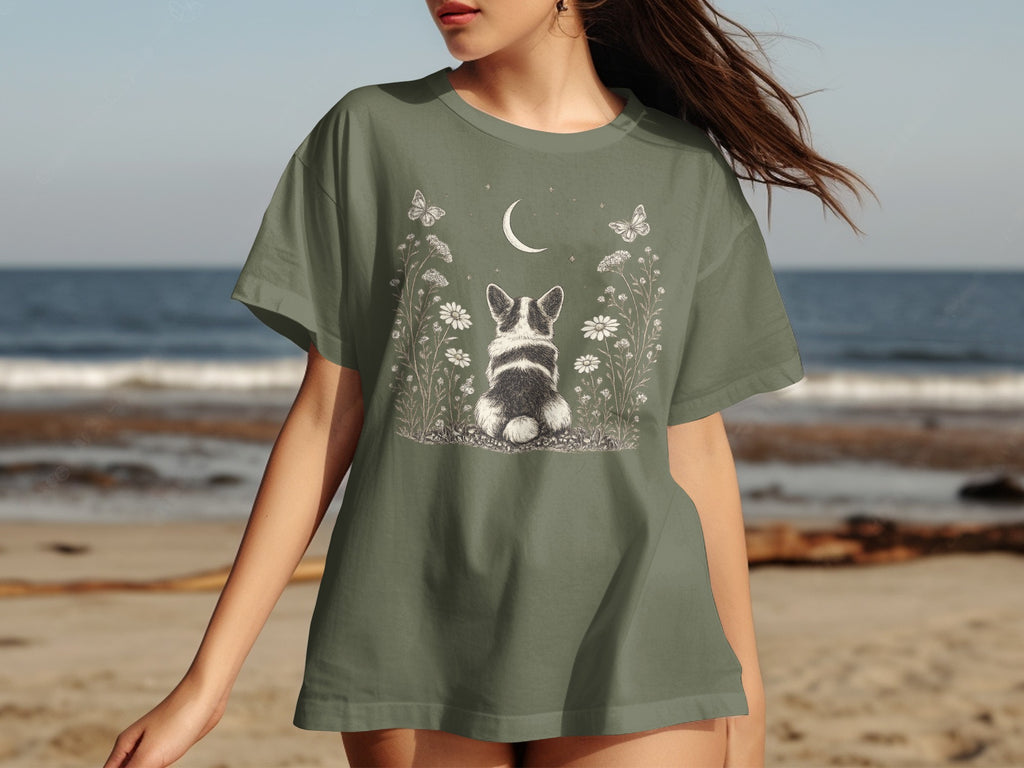 Green t-shirt with a dog, moon, butterflies, and flowers graphic.