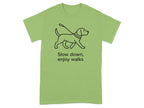 Green t-shirt with black line drawing of a dog on a leash and text "Slow down, enjoy walks".