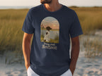 T-shirt with a spotted dog gazing at a sunset over water, text "Paws And Reflect".