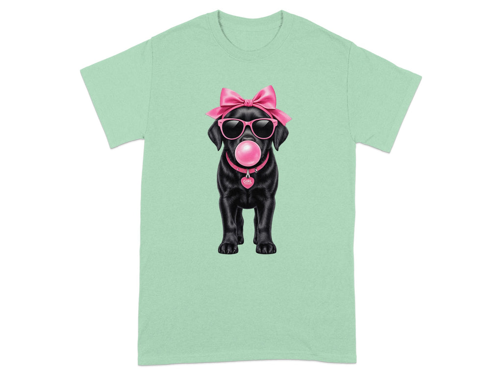 Black Labrador puppy wearing sunglasses, a pink bow, and a pink collar with a heart tag.