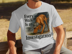White t-shirt with a Vizsla wearing a hat and the text "Every Walk Is an Investigation".