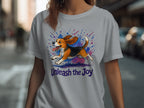 A beagle runs with "Unleash the Joy" text on a grey t-shirt.