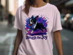 Boston Terrier illustration with "Unleash the Joy" text on a light pink t-shirt.
