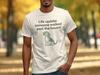 White t-shirt with text "Life update: someone walked past the house!" and dog graphic.