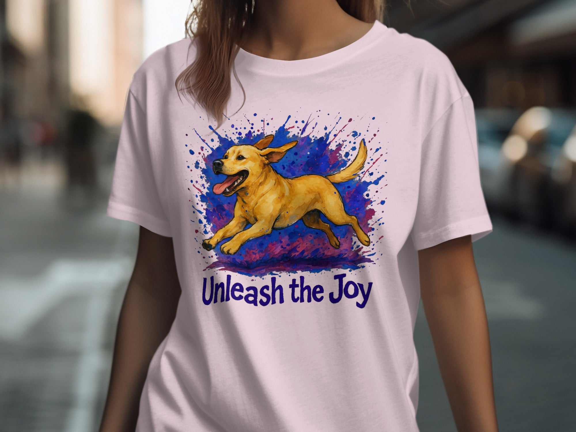 T-shirt with yellow dog running on colorful splatters, text "Unleash the Joy".