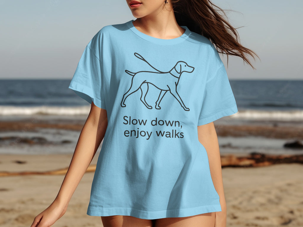 Light blue t-shirt with line drawing of dog and text "Slow down, enjoy walks".
