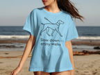 Light blue t-shirt with line drawing of dog and text "Slow down, enjoy walks".