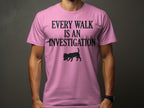 Pink t-shirt with "EVERY WALK IS AN INVESTIGATION" and dog silhouette.