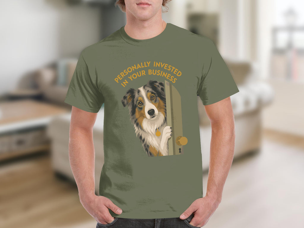 Man in green t-shirt with Australian Shepherd peeking around a door.