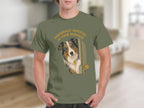 Man in green t-shirt with Australian Shepherd peeking around a door.