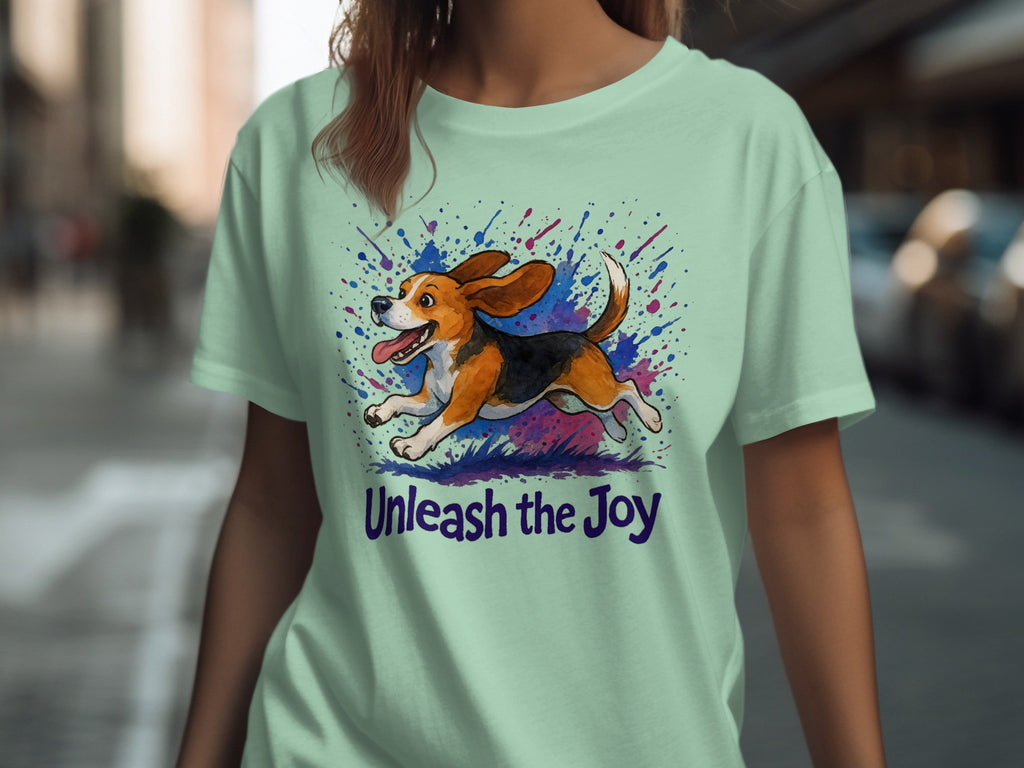 Mint green t-shirt with beagle running through paint splatters and text "Unleash the Joy".