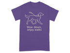 Purple t-shirt with a line drawing of a dog on a leash and text "Slow down, enjoy walks".