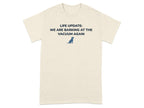 Cream t-shirt with text "LIFE UPDATE: WE ARE BARKING AT THE VACUUM AGAIN" and a small dog graphic.