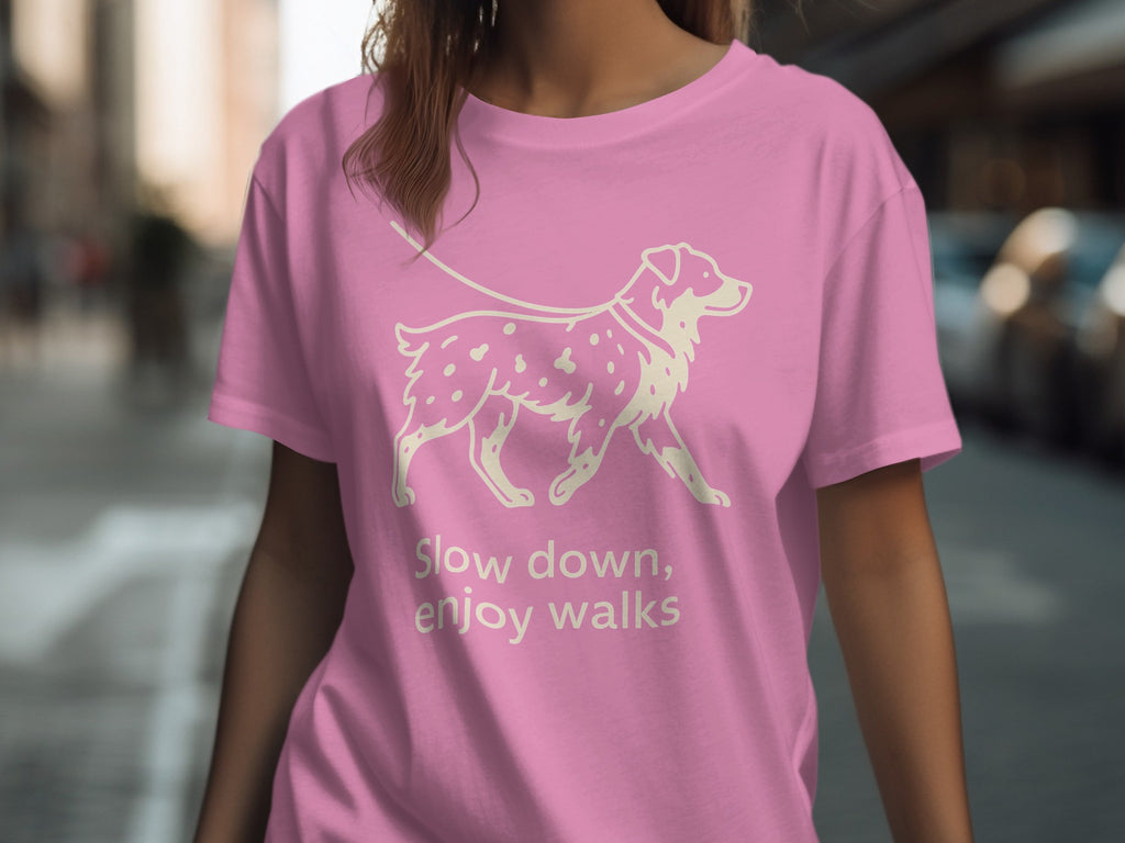 Pink t-shirt with a cream line drawing of a dog on a leash and text.