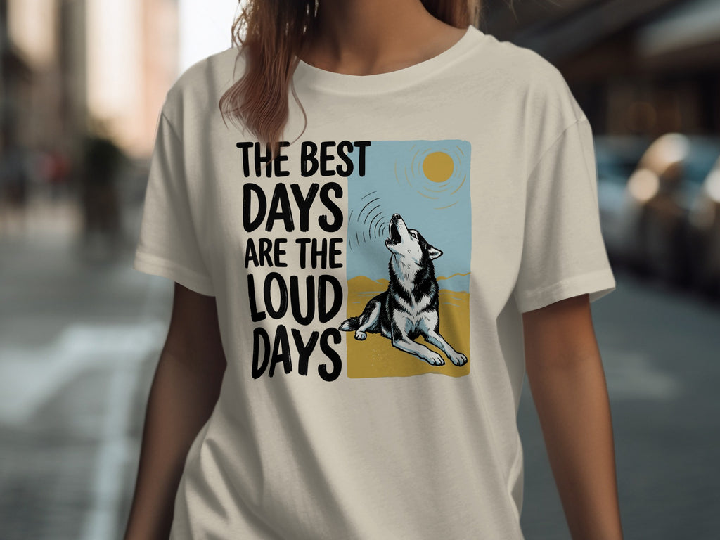 Cream t-shirt with graphic of a wolf howling at the sun and text "The best days are the loud days".