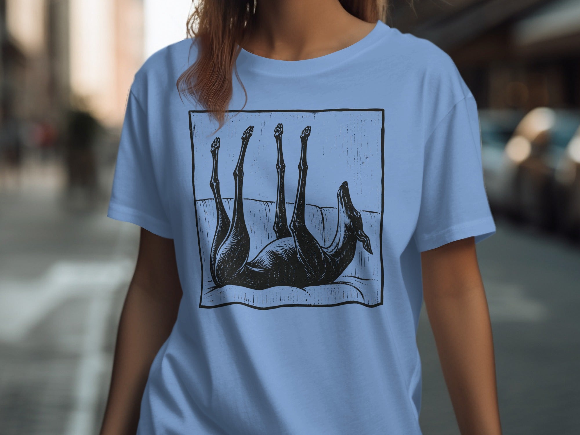 Light blue t-shirt with black screen print of a dog lying on its back.